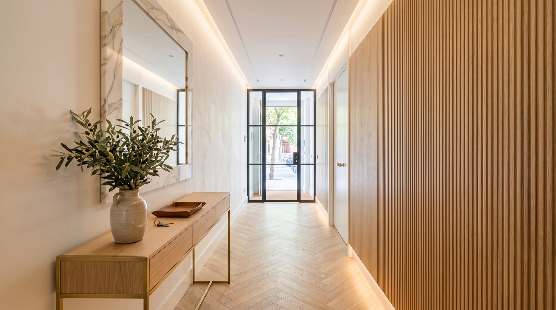 Hall y entrada reformada en Madrid con paneles de roble