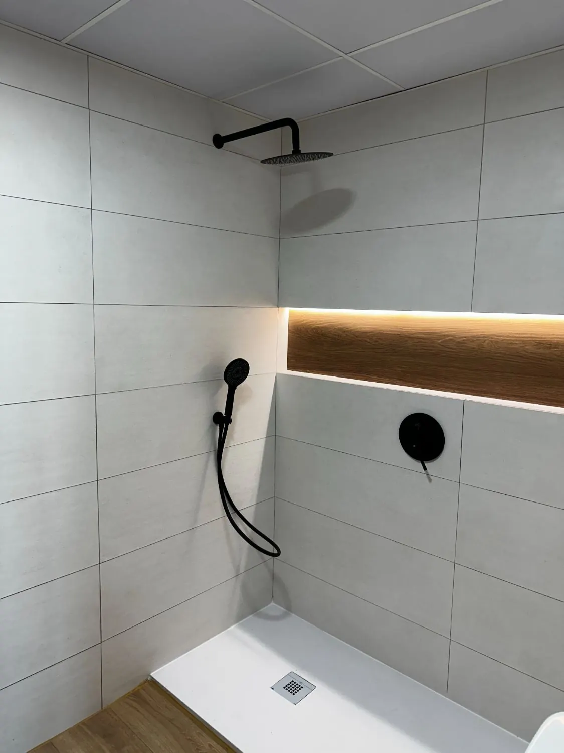 Ducha terminada con hornacina iluminada y grifería negra