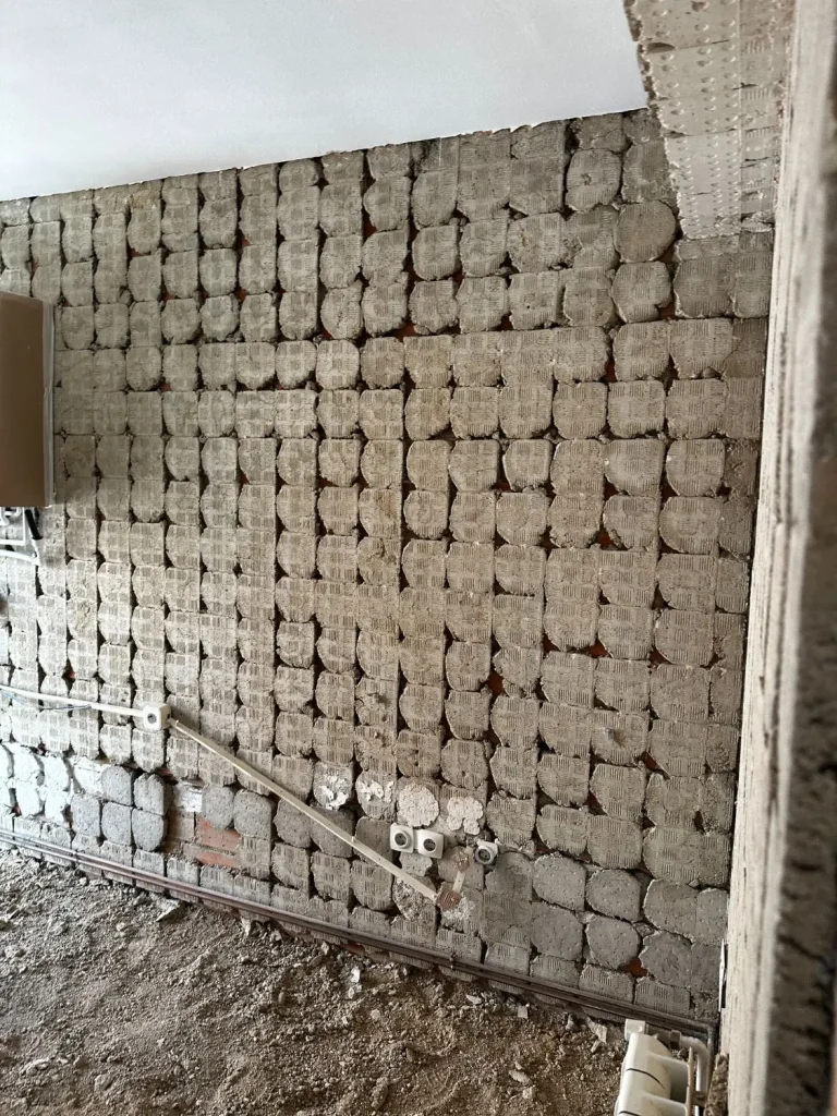 Muro picado hasta el ladrillo durante la demolición