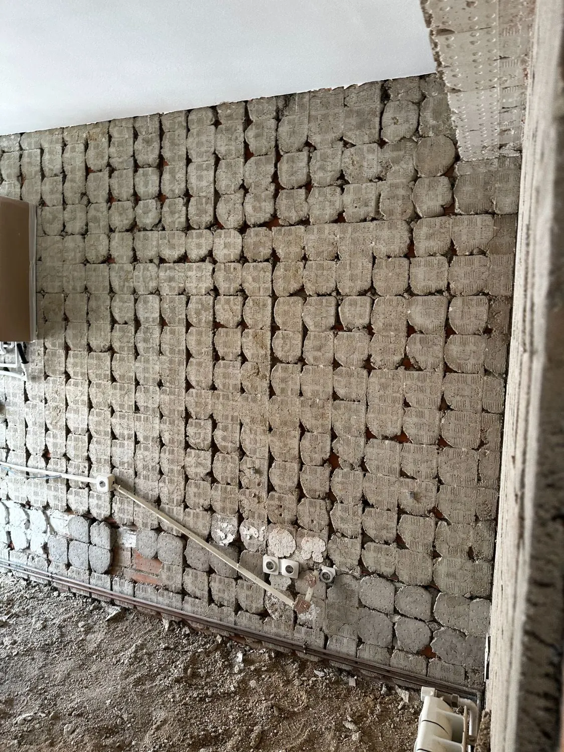 Muro picado hasta el ladrillo durante la demolición